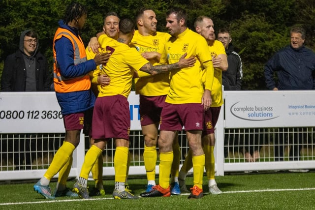 James Knowles celebrates scoring Emley's first equaliser with teammates.
