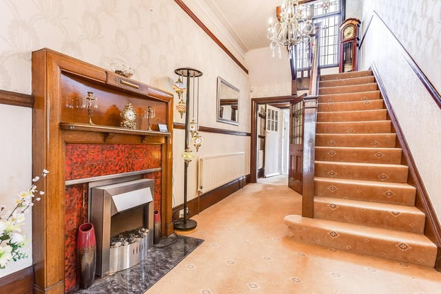 A large fireplace takes pride of place in this hallway, with staircase leading up to the upper two floors.