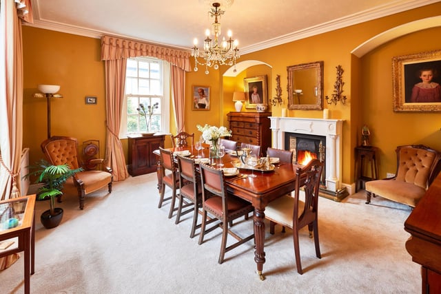 The formal dining room, again with a striking fireplace, and period decorative detail.