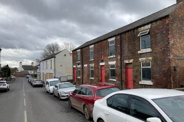 More than 100 village residents have objected to a scheme to convert a derelict former business premises into flats and retail units.
