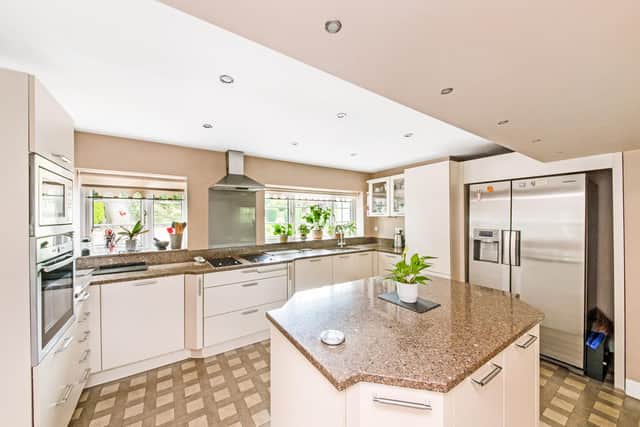 The kitchen has integrated appliances, quartz worktops and a central work island.