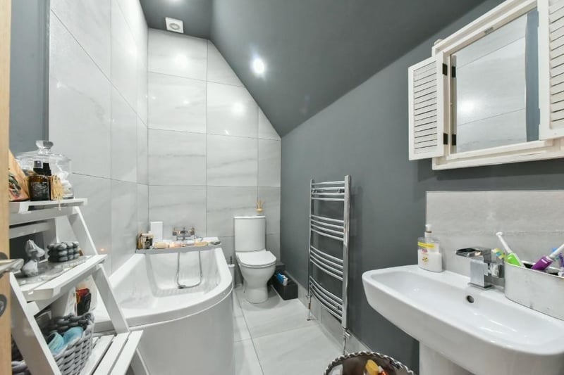 The family bathroom includes a chrome heated towel rail, tiled floor to ceiling over bath and a push button w.c.
