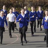 Lucy Scott , Summer Shaw and Millie Parkinson lead fellow pupils at Normanton Junior Academy on a run. The trio organised a two-day runathon to raise money for the MND Association. Picture Scott Merrylees