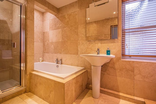 A stylish bathroom with both bath and shower within its suite.
