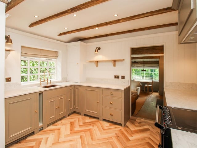 The kitchen is fitted with a range of handmade solid wood units complemented by quartz work surfaces, an inset copper sink and quality fixtures and fittings.