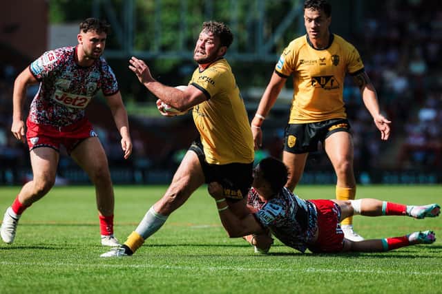 Castleford Tigers' Joe Stimson is tackled by David Armstrong, of Leigh. Picture by Alex Whitehead/SWpix.com