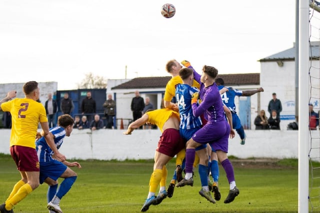 Frickley Athletic goalkeeper Charlie Preston looks to punch clear.