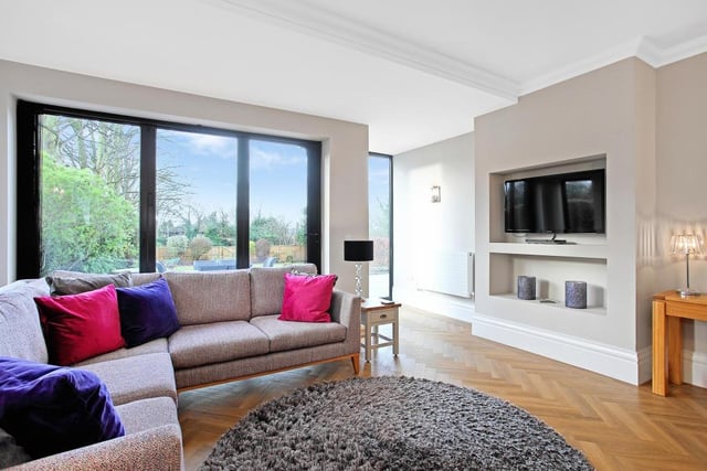 This great room features housing for the television and display shelving, downlighting to the ceiling, four wall light points and two central heating radiators.