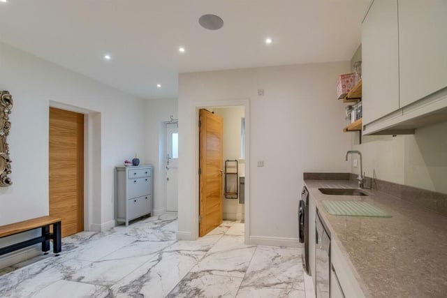 The utility room has a built in double fronted drying cupboard and a broad range of fitted wall and base units with a Quartzstone worktop incorporating a stainless steel sink unit.