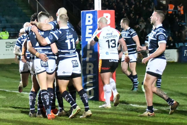Featherstone Rovers players celebrate scoring a try.