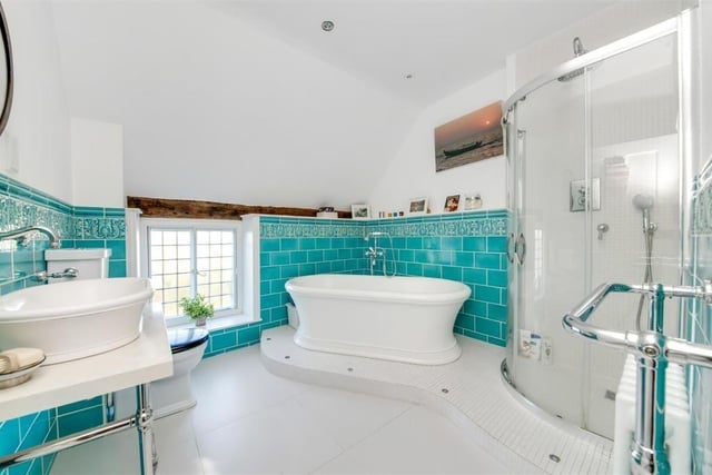 A luxurious bathroom with free standing, double ended bath tub and walk-in shower.