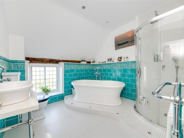 A luxurious bathroom with free standing, double ended bath tub and walk-in shower.