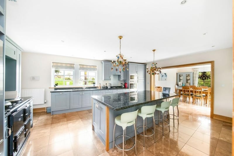 The open plan breakfast kitchen with quality appliances has a central island with breakfast bar, and an Aga.