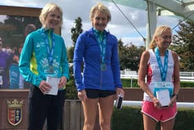 Christine McCarthy at the top of the podium after receiving her award as winner of the international marathon against the Celtic nations in the Women's Over 60 age group at Chester.