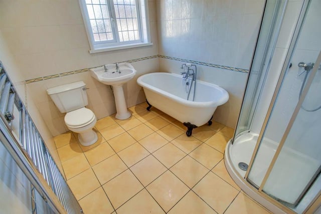 A bathroom with free standing bath tub and separate shower cubicle.