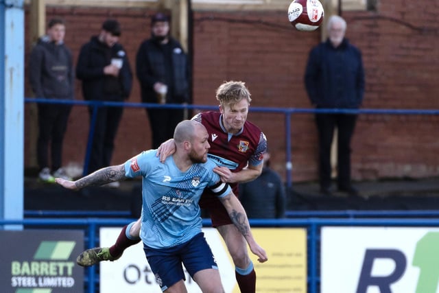 Pontefract Collieries' defender Spencer Clarke competes with Ossett United's Danny South for a high ball.