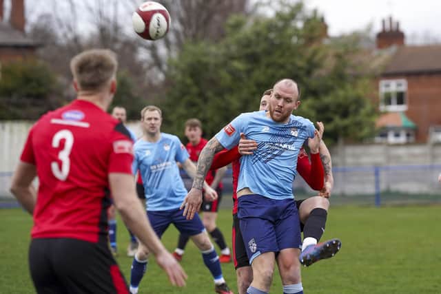 A Sheffield defender is hands on with Ossett United's Danny South. Picture: Scott Merrylees