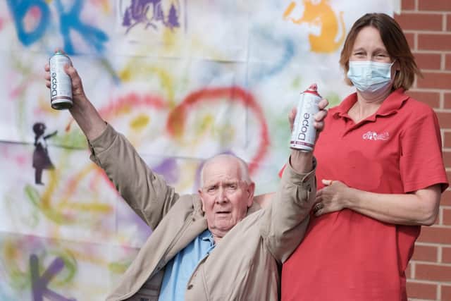 Hemsworth Park Care Home resident Joseph Russell with team member Heather learning how to graffiti spray-paint.
