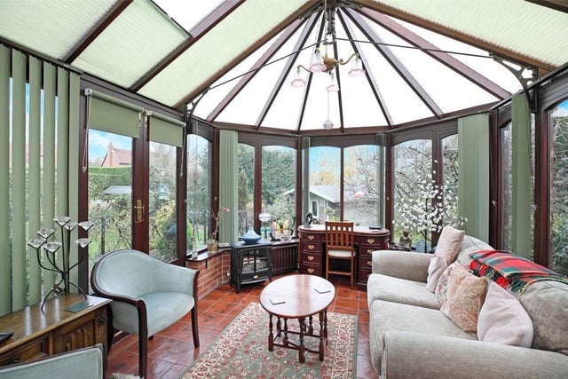 The spacious conservatory is surrounded by garden views.