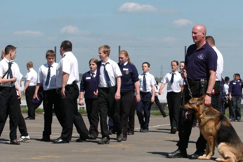 Dog handler Kev Smith from HMP Wakefield watches over pupils from Wakefield City High School as they take part in a mock prison exercise session.