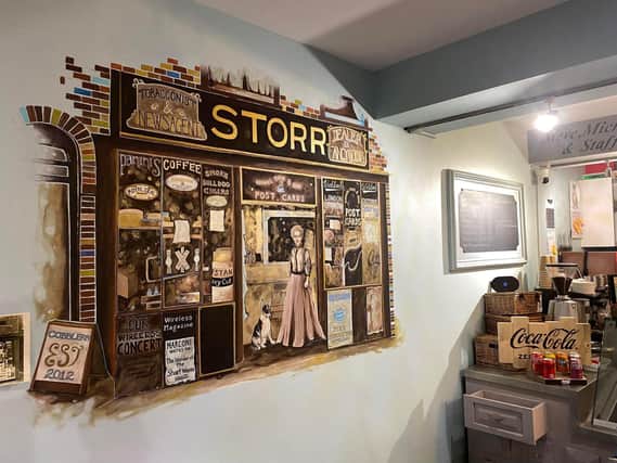 The mural is based on an old photograph of the previous shop of 103 Westgate in the 1920s.