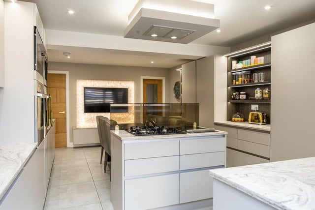 The breakfast kitchen is presented with a range of contemporary wall and base hardwood storage units with bronze splashback mirrors. A plethora of integral appliance include; a double oven, a large grill including Tepiyanki grill, an American fridge freezer and a dishwasher.