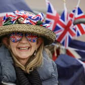 A royal enthusiast smiles on The Mall as preparations continue for the Coronation of King Charles III. Photo by Jeff J Mitchell/Getty Images