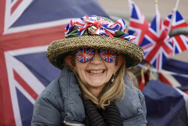 A royal enthusiast smiles on The Mall as preparations continue for the Coronation of King Charles III. Photo by Jeff J Mitchell/Getty Images