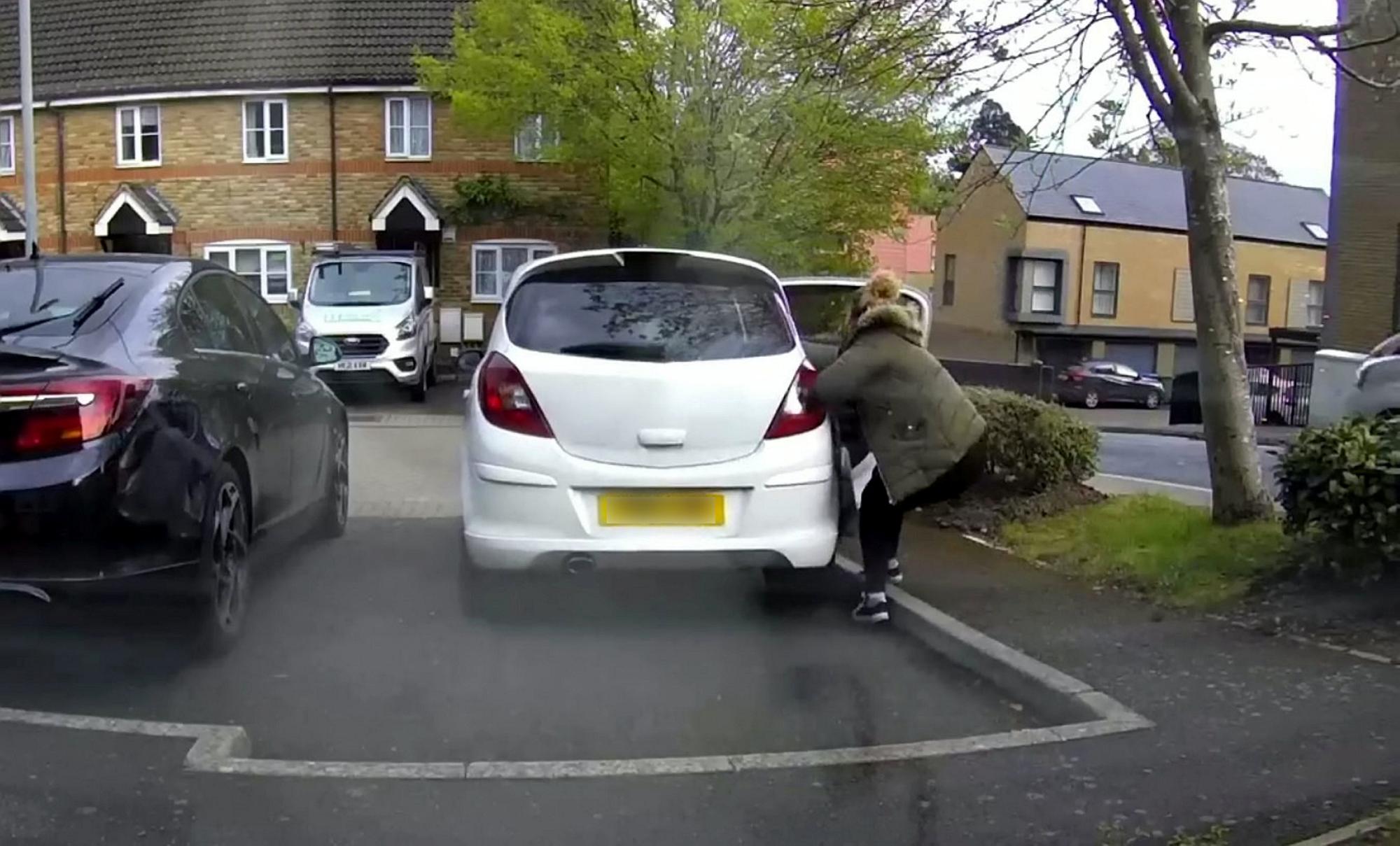 Watch the hair-raising moment woman tries to stop her runaway car ...