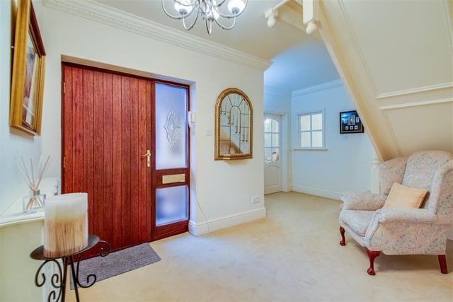 A solid wood entrance door leads in to the spacious hallway of the house.