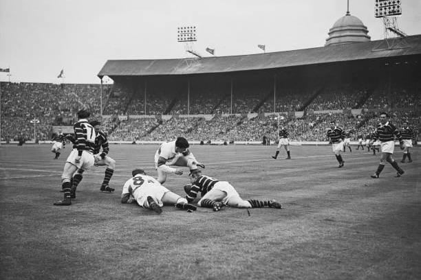 An Huddersfield player holds the ball on the ground under pressure from Wakefield Trinity players during the Challenge Cup final between Wakefield Trinity and Huddersfield at Wembley Stadium in London, England, May 12, 1962. Wakefield Trinity won the match 12-6. (Photo by Evening Standard/Hulton Archive/Getty Images)