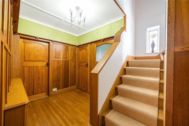 The ground floor entrance hallway is fit with original wood panelling.