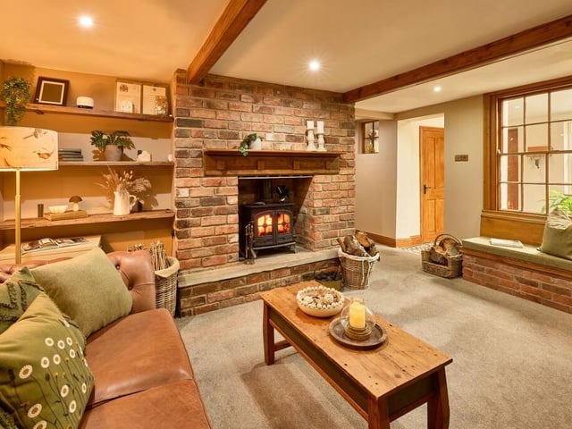 The cosy family lounge has an exposed brick chimney breast as the focal point with original beams running overhead.