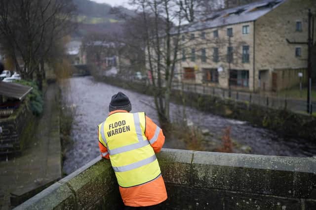 A volunteer flood warden checks the river levels of the River Hebden following rain and melting snow in Hebden Bridge. Photo by Christopher Furlong/Getty Images