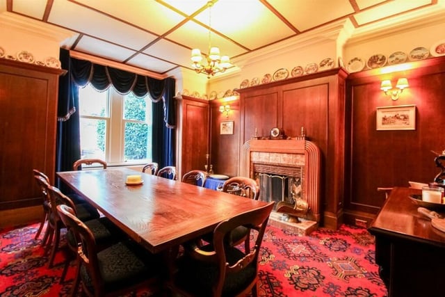 The dining room features a central heating radiator, coving to the ceiling, panelling to the walls with picture rail and an art deco style open fireplace with tiled hearth that's surrounded with a wooden mantle.