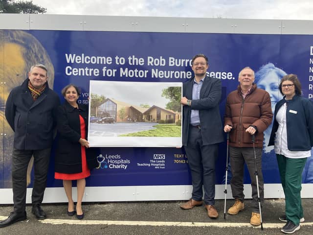 An MND patient, staff, charity representative and architects with plans for the centre