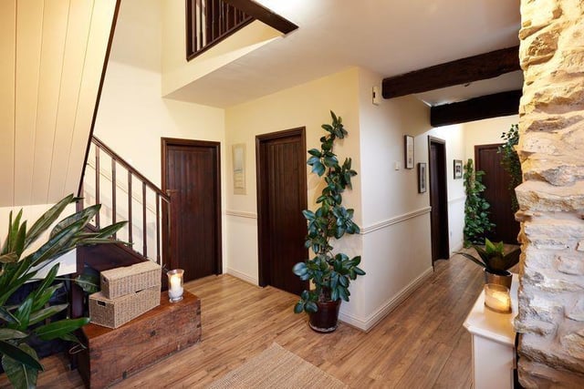 The beamed hallway of the property has stairs to a mezzanine landing.