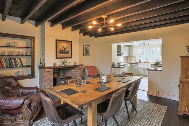 The cosy beamed dining room has original beams and a wood burning stove.