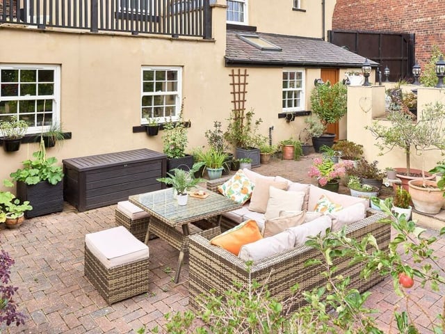 A generous, gravelled driveway leads down to a large patio area.