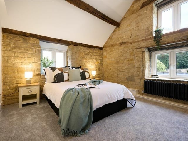 Up the stairs is the third of the double bedrooms which features exposed beams retaining their original hooks, a vaulted ceiling and exposed brick walls.