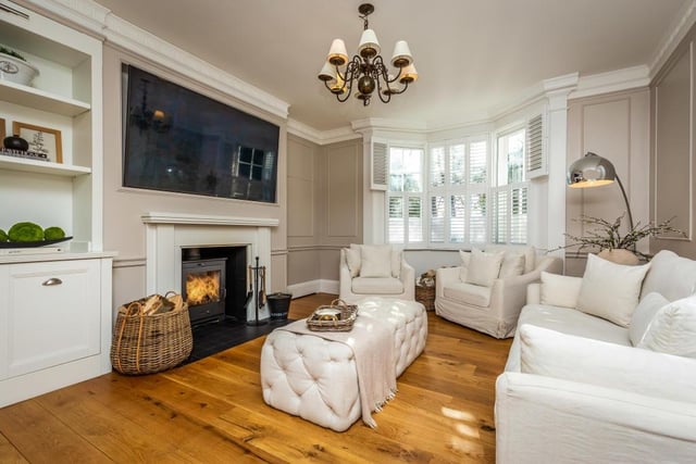The stunning drawing room with multi-fuel stove is filled with light from its large bay window, and also features an arched recess and decorative detail.