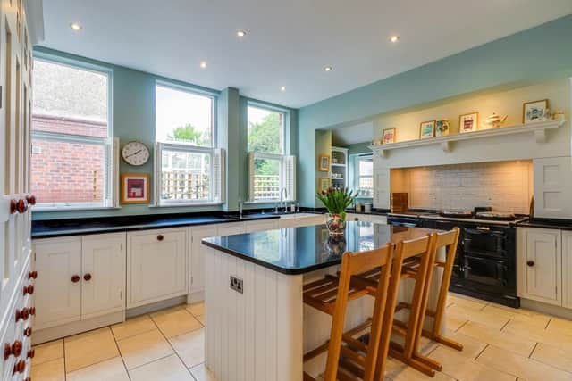 The light and spacious kitchen with a central work island and breakfast bar.