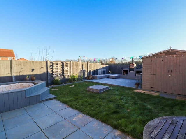 Looking across the rear garden of the property with lawn and decked area.