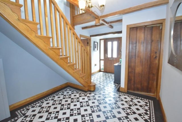 Karndean flooring, a wooden staircase and doors create a stylish entrance hallway.