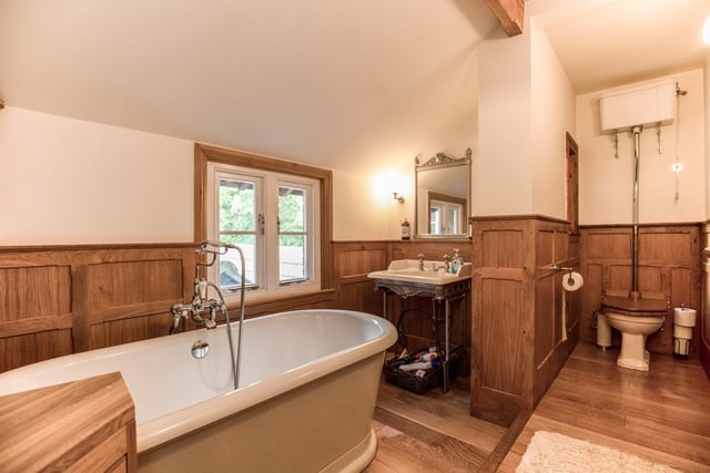 A deep, free standing bath takes pride of place in this spacious panelled bathroom.