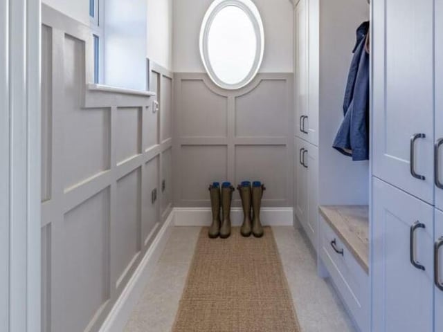 A solid oak door leads into an entrance vestibule and the boot room with bespoke cabinetry.