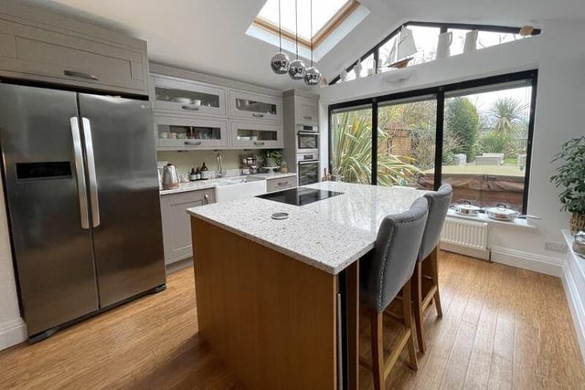 The light and stylish breakfast kitchen has views of the garden.