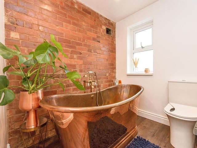 An inviting, deep copper bath within one of the bathroom facilities.
