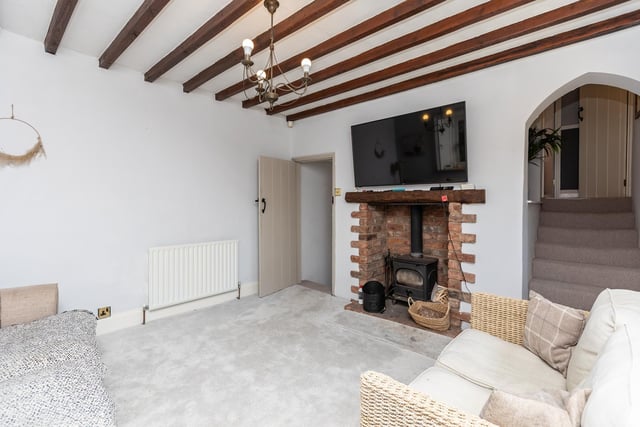 The beamed lounge with open brick fireplace and cosy stove.