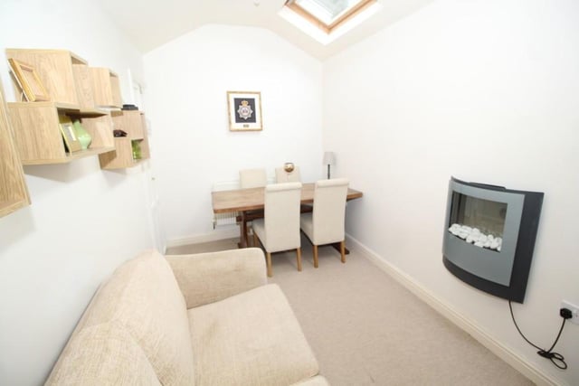 The dining room or bedroom has a wall-mounted electric fire and two velux windows.
